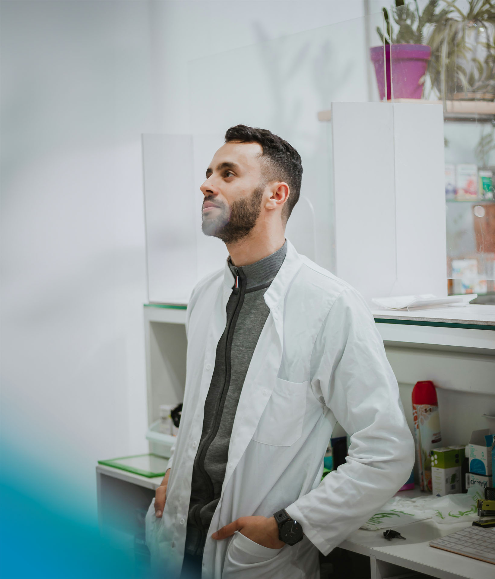 Junger Apotheker mit Laborkittel in einer Apotheke
